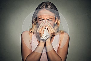 Woman sneezing blowing her runny nose