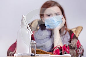 Woman with sneezing nose blowing in tissue suffering winter cold and flu virus symptoms having medicines tablets and pills in illn