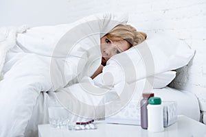 woman with sneezing nose using tissue on bed suffering cold flu virus having medicines