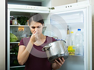 Woman sniffing at foul food