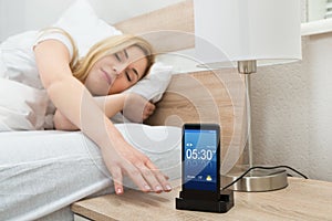 Woman Snoozing Alarm On Mobile Phone Screen