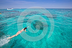 Woman snorkeling in the blue sea