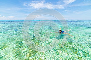 Woman snorkeling in caribbean on coral reef tropical turquoise blue water. Indonesia Wakatobi archipelago, marine national park,