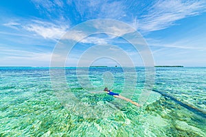 Woman snorkeling in caribbean on coral reef tropical turquoise blue water. Indonesia Wakatobi archipelago, marine national park,