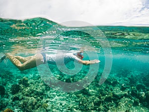 woman snorkeling in clear tropical sea