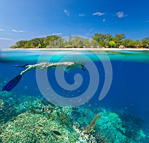 Woman snorkeling in clear tropical waterson a background of exot