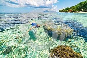 Woman snorkeling on coral reef tropical caribbean sea, turquoise blue water. Indonesia Banda archipelago, Moluccas Maluku, tourist photo