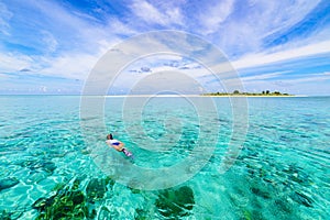 Woman snorkeling on coral reef tropical caribbean sea, turquoise blue water. Indonesia Wakatobi archipelago, marine national park