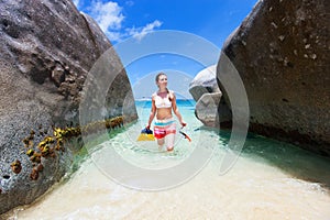 Woman with snorkeling equipment at tropical beach