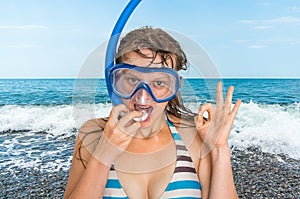 Woman with snorkeling mask for diving stands near the sea