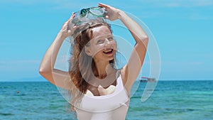 Woman snorkeling in turquoise sea, taking off mask.