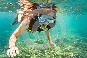 Woman snorkelling over floor of tropical sea photo