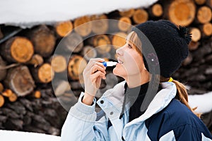 Woman at the snow applying protective cream