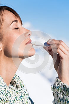 Woman on the snow applying a protective cream