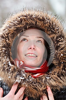 Woman in snow forest with neckpiece and red scarf smiling