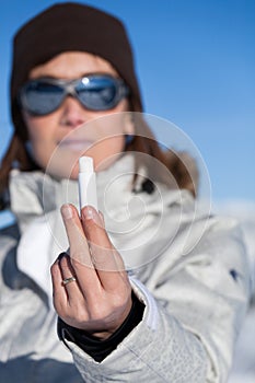 Woman in the snow with a lipstick protector