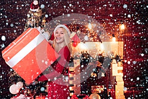 Woman in snow. Merry Christmas and happy new year. Sensual Christmas girl with big gift box. Beautiful girl portrait