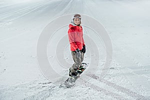 Woman with snowboard on the ski slope. Evening riding