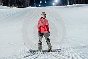 Woman with snowboard on the ski slope. Evening riding