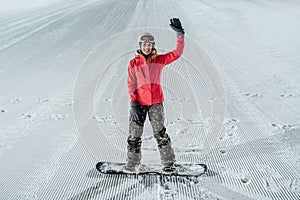 Woman with snowboard on the ski slope. Evening riding