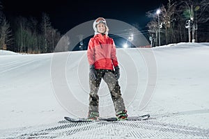 Woman with snowboard on the ski slope. Evening riding