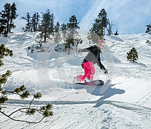 Woman snowboarder in motion in mountains