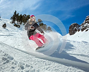 Woman snowboarder in motion in mountains