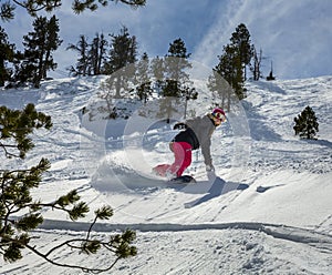 Woman snowboarder in motion in mountains