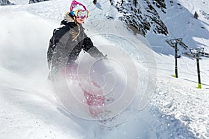 Woman snowboarder in motion in mountains