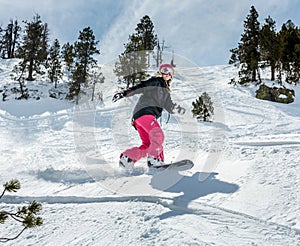 Woman snowboarder in motion in mountains