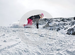 Woman snowboarder in motion in mountains