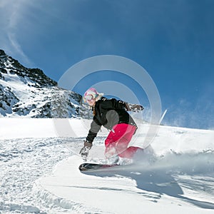 Woman snowboarder in motion in mountains