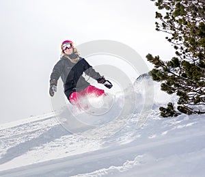 Woman snowboarder in motion in mountains