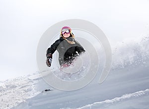 Woman snowboarder in motion in mountains