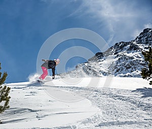 Woman snowboarder in motion in mountains