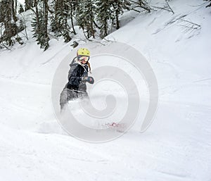 Woman snowboarder in motion in mountains