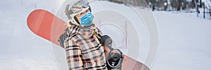 Woman snowboarder on a sunny winter day at a ski resort wearing a medical mask during COVID-19 coronavirus BANNER, LONG