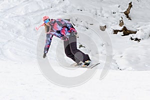 Woman snowboarding on the piste in winter