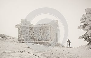 Woman with snowshoes entering a mountain hut photo