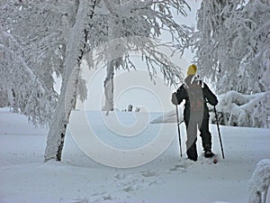 Woman with snowshoes in winter forest