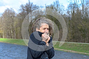 Woman snuggling into her jacket on a cold day