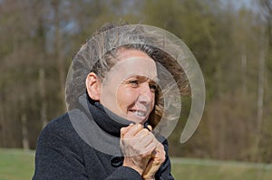 Woman snuggling into her jacket on a windy day