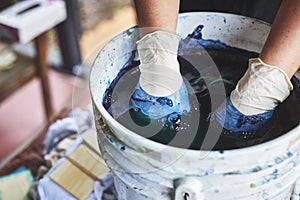 A woman soaking fabric in indigo dye