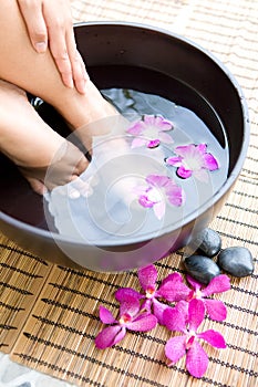 Woman soaking feet in bowl of water