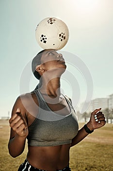 Woman, soccer ball and balance on head in training grass field, sports ground or fitness training club. Football player