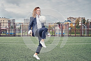Woman soccer player in an office suit stuffs the ball with her head. concept