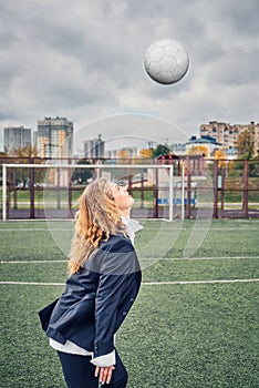 Woman soccer player in an office suit stuffs the ball with her head. concept