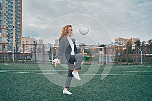 woman soccer player in an office suit stuffs the ball with her head. concept.