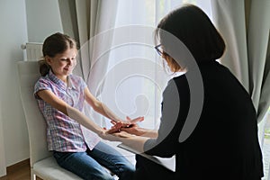 Woman social worker psychologist talking to girl child in office