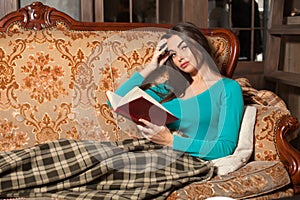 Woman on sofa with book